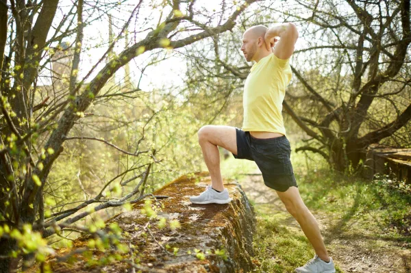 Homme s'étirant en pleine nature, symbole de discipline, de bien-être et de développement personnel