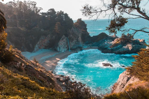 Plage sauvage avec cascade se jetant dans l'océan turquoise